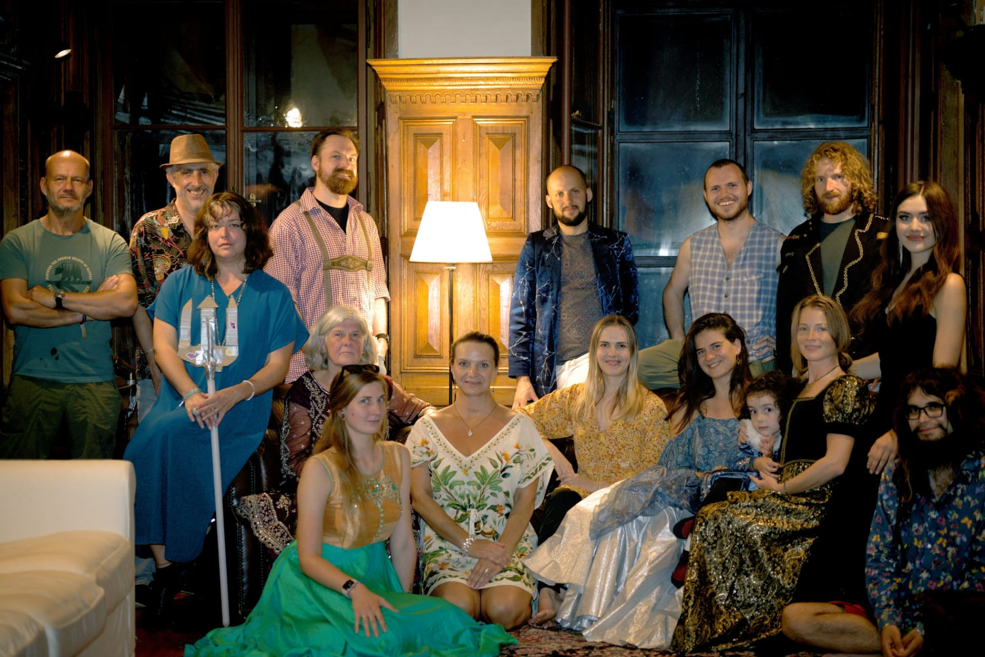 Residents and friends gathered together in a lamp-lit wood-panelled room at Hostačov